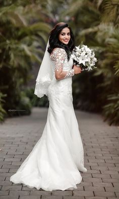 a woman in a wedding dress holding flowers