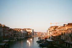 a river running through a city with lots of buildings on both sides and boats in the water