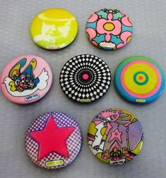 six different colored buttons with designs on them