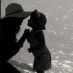 a woman and child standing in the water