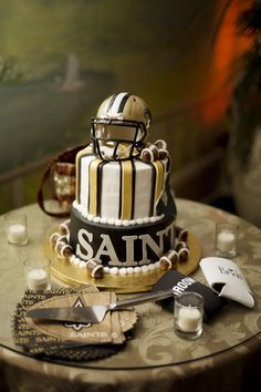 a football themed cake on a table with candles and other decorating items around it