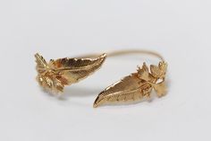 This bracelet is made out of a couple of delicate leaves along with small, intricate and detailed pine cones, all soldered onto a flexible bracelet base.If you need that little touch of nature added into your all over look- this one is for you.* Comes wrapped in a pretty gift bag.* Could be requested in 14k gold, rose gold or silver plated brass.* The small leaves on the front of the bracelet might slightly change depending on availability.For updates, new products, one-of-a-kind's, special offe Nature-inspired Wedding Bracelet Jewelry, Nature-inspired Wedding Bracelet, Bridal Jewelry Gold, Branch Bracelet, Gold Bridal Jewelry, Bohemian Headband, Small Leaves, Flexible Bracelet, Gold Wrap