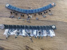 two pieces of denim with beaded fringes and beads on the ends, sitting on top of a wooden table