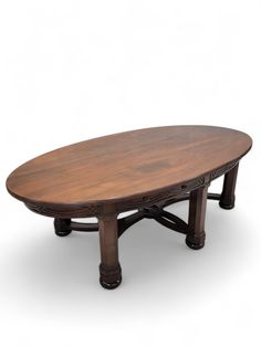 an oval wooden table sitting on top of a white floor