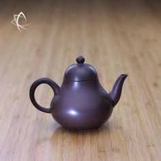 a small teapot sitting on top of a wooden table