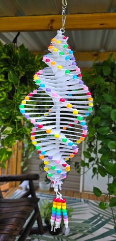 a wind chime hanging from a tree with colorful beads on it's strings