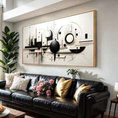 a living room with black leather couches and large art on the wall above it