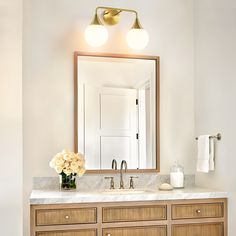 a bathroom vanity with two lights and a mirror