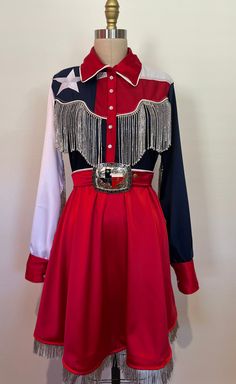 You won't be lonely for long in the lone star dress! Made to order a line pearl snap dress features rhinestone fringe and silver metallic fringe. Dress is made out of a high quality satin and Texas flags. Dress comes complete with a matching satin belt with oversized Texas belt buckle. 70s Texas Fashion, Cowgirls Costume, Royalty Outfits, Long Closet, Texas Belt Buckle, Texas Dress, Usa Costume, Rodeo Dress, Cowgirl Dress