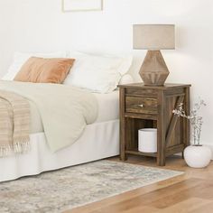 a bedroom with a bed, nightstand and rug