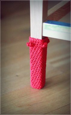 a small crocheted object sitting on top of a wooden floor next to a window