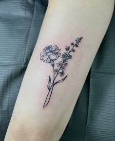 a small flower tattoo on the arm