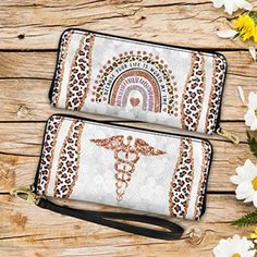 two white wallets sitting on top of a wooden table next to flowers and a stethoscope