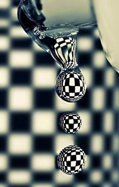 three balls floating in water on a black and white checkered surface