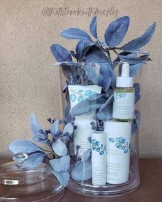 a clear container filled with blue flowers and personal care items