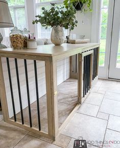 a table that has some plants on top of it in front of a door and windows