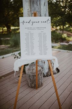 a wooden easel with a calendar on it sitting in front of a tree trunk