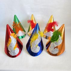 Vintage Set of 6 Cardboard Kids Party Hats, assorted metallic colors.  Please judge condition by pictures, like they say a picture is worth a thousand words. Country of Origin: USA Maker/Designer: No makers mark Measures Approx: 8" Condition:  Items are sold in as is condition. Various signs of wear, creases, bends, scratches. The yellow feather on the blue hat is broken near the top and due to age the elastics are not very stretchy. NO RETURNS OR EXCHANGES But please contact me if you have any Cardboard Kids, Kids Party Hats, Yellow Feathers, Vintage Hats, Vintage Party, Blue Hat, Black Spot, Metallic Colors, Hats Vintage