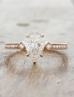 an engagement ring with a pear shaped diamond