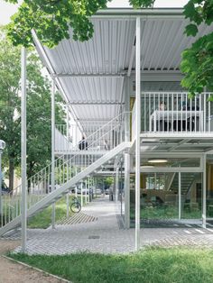 an open air building with stairs leading up to the top floor and second story above it