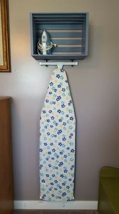 an ironing board is hanging on the wall next to a shelf with a blue and white tie