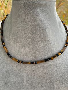 Choker is made from genuine tigers eye and black onyx beads. Length is 16 1/4" and has a chain adjustment. Item 116 Brown Necklaces With Black Beads For Gift, Adjustable Brown Necklace With Black Beads, Adjustable Brown Crystal Necklace With Polished Beads, Masculine Beaded Necklace, Men's Black Beaded Necklace, Adjustable Hematite Necklace With Black Beads, Black Faceted Beads Choker, Adjustable Hand-strung Onyx Necklace, Tube Bead Bracelet