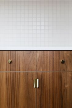 a wooden cabinet with brass handles and knobs in a kitchen or dining room area