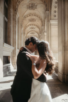 a bride and groom dance together in an old building with stone arches on either side