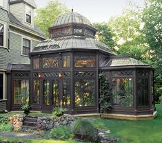 a gazebo sitting in the middle of a lush green yard next to a house