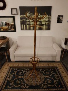 a living room with a white couch and a gold candelabra on the floor