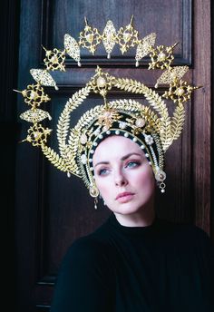 This wonderful golden halo headdress is a truly special statement piece! The 'Frida' halo is made from a soft base of black chenille and velvet, adorned with beautiful golden filigrees and pearls. Crystals twinkle here and there to further catch the light and add to the drama of this piece.  Made to order - please allow for some variation in the creation of this headdress. Trim/crystals may vary. Gold Structured Crown Headpiece For Festival, Gold Ceremonial Headpiece With Round Crown, Gold Ceremonial Headpiece With Tall Crown, Gold Crown Headpiece For Festivals, High Crown Gold Headpiece For Festival, Gold High Crown Headpiece For Festivals, Elegant Gold Costume Hats And Headpieces For Ceremonial, Traditional Gold Costume Hats For Party, Traditional Gold Structured Crown Headpiece