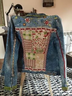 an old jean jacket is sitting on top of a stool in front of a mirror