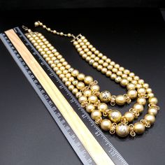 *Description: This is a beautiful Japan necklace which has a variety of gold round glass beads with accent art beads in a shiny and brushed gold with looped chain beads as spacers, from the 1950s. Japan necklaces have very unique and artistic bead accents. This would be a great addition to your vintage jewelry collection or make a great vintage gift! *Approximate Measurements: Length of shortest strand - 18 Inches *Condition: Great vintage condition. Can see string, when hanging, near the ends w Luxury Vintage Gold Beads, Gold Beaded Necklace, Accent Art, Necklace Art, Gold Bead Necklace, 1950s Vintage, Bead Art, Vintage Gifts, Gold Beads