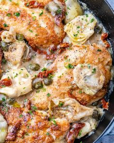 chicken and artichokes in a skillet with parmesan cheese sauce