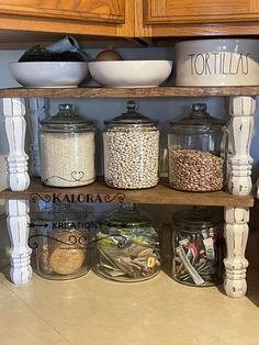 a kitchen shelf filled with lots of different types of food in jars and bowls on top of it