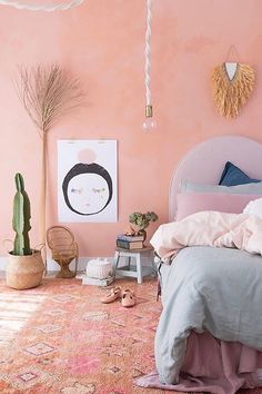 a bedroom with pink walls and an area rug that has various items on the floor