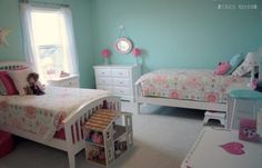 a child's bedroom with blue walls and white furniture