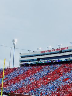 a large stadium filled with lots of red and blue people sitting on the bleachers