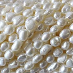 white pearls are arranged in rows on a white surface