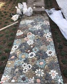 a walkway made out of rocks and stones with plastic bags on the ground next to it