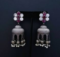 Gather compliments wearing this Indian jhumka earrings with flashy CZ ear studs. In faux diamond, ruby, emerald, and blue sapphire. Voluptuous shape. Very feminine and pretty! Tiny dangly metal balls and pearls finish the look. Earrings are cast metal, not stamped, so they look and feel substantial. find even more great earrings here: https://www.etsy.com/shop/boutiquebymaryam?section_id=22797814 Be sure to visit the rest of my shop here: https://www.etsy.com/shop/boutiquebymaryam All my jewelry Silver Jeweled Earrings For Festive Occasions, Silver Jeweled Earrings For Festive Season, Festive Jeweled Silver Earrings, Silver Jeweled Dangle Earrings, Jeweled Jhumkas Drop Earrings For Gift, Silver Jeweled Jhumkas For Wedding, Silver Jeweled Earrings For Diwali, Bollywood Ruby Earrings For Gift, Silver Jeweled Jhumkas For Gifting