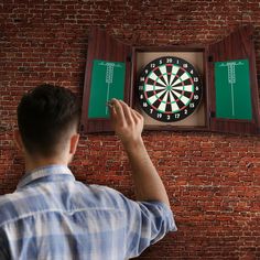 a man is pointing at a dart on the wall