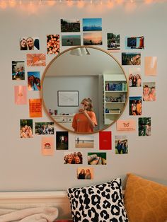 a woman taking a selfie in front of a mirror with many pictures on it