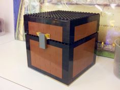 a lego chest sitting on top of a table next to a cup and candle holder