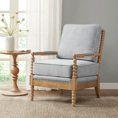 a living room with a chair and table in front of a window on the floor