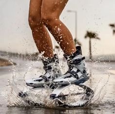 a person riding skis on top of a puddle in the street with water splashing around