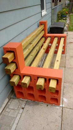 an orange bench sitting on the side of a house