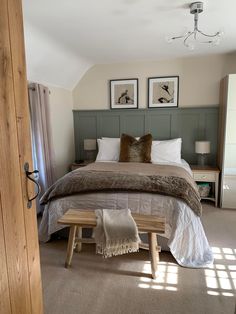 a bed room with a neatly made bed and two pictures on the wall