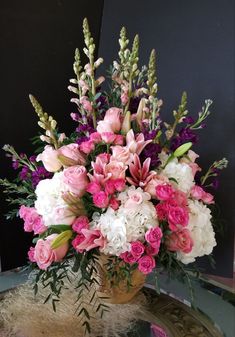 a vase filled with pink and white flowers on top of a table