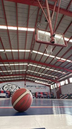 an indoor basketball court with a red and white ball